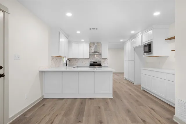 a kitchen with white cabinets stainless steel appliances and sink
