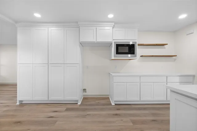 a kitchen with white cabinets and stainless steel appliances