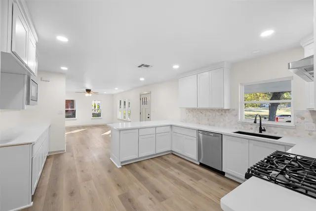 a kitchen with a sink a stove and cabinets