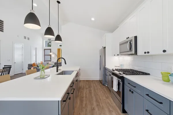 a kitchen with stainless steel appliances a sink a stove a counter space and cabinets