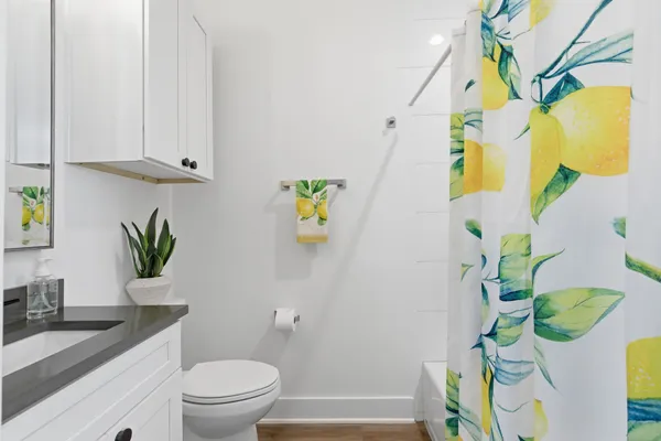 a bathroom with a granite countertop sink a toilet and a mirror