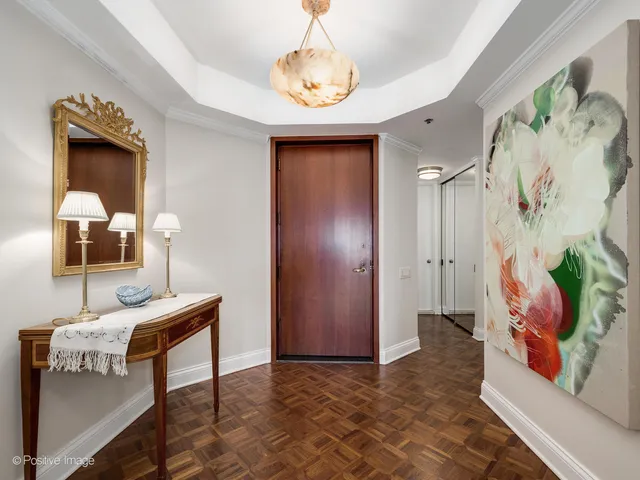 a view of a hallway with wooden floor and a vase of flowers
