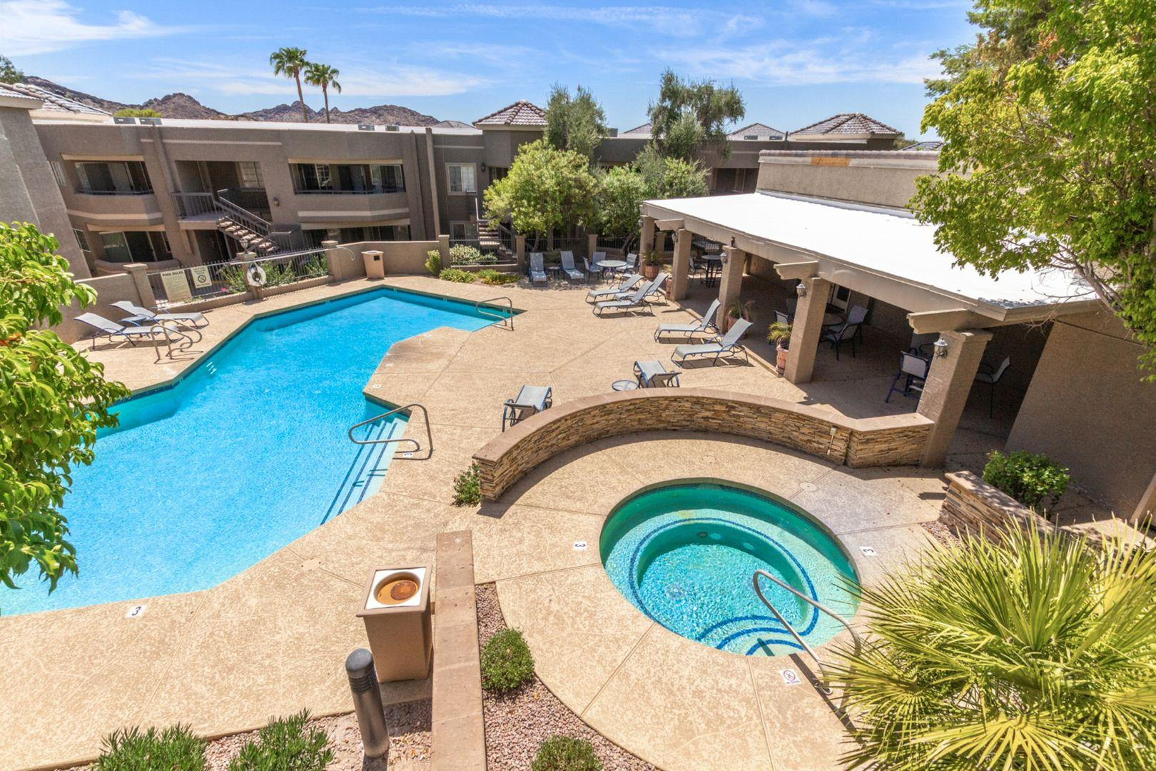 a view of a swimming pool with a patio and a yard