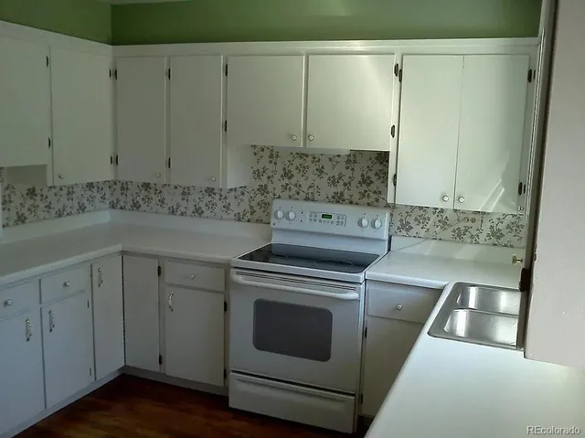 a kitchen with a stove and white cabinets