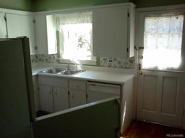 a sink with window and refrigerator