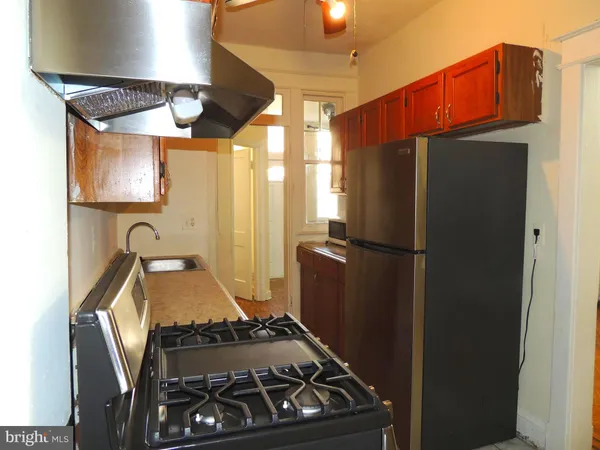 a kitchen with stainless steel appliances granite countertop a refrigerator and a stove