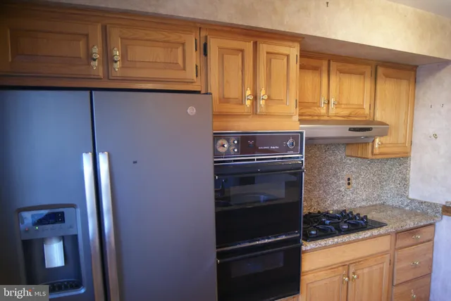 a kitchen with granite countertop stainless steel appliances and cabinets