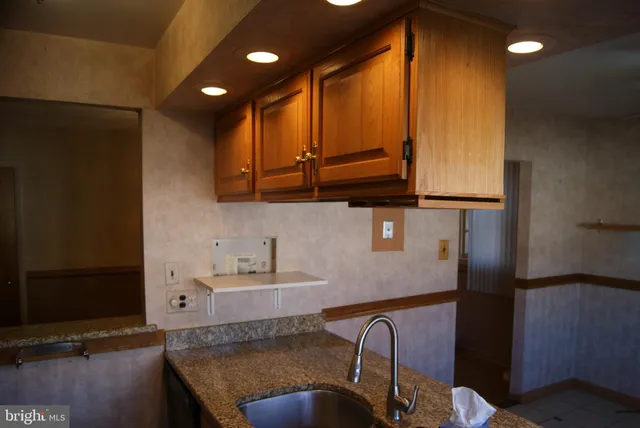 a kitchen with a sink a refrigerator and cabinets