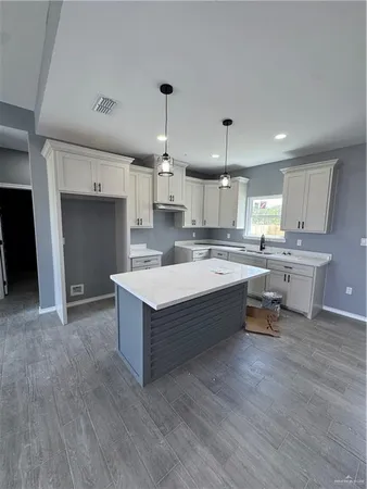 a large kitchen with kitchen island a sink stainless steel appliances and cabinets