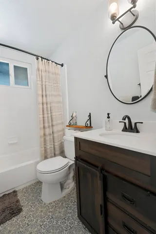 a bed sitting in a spacious bedroom next to a cabinet