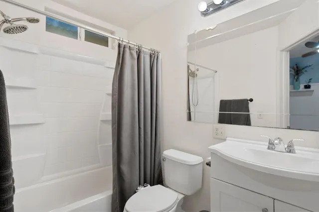 a bedroom with a bed a table and a large window