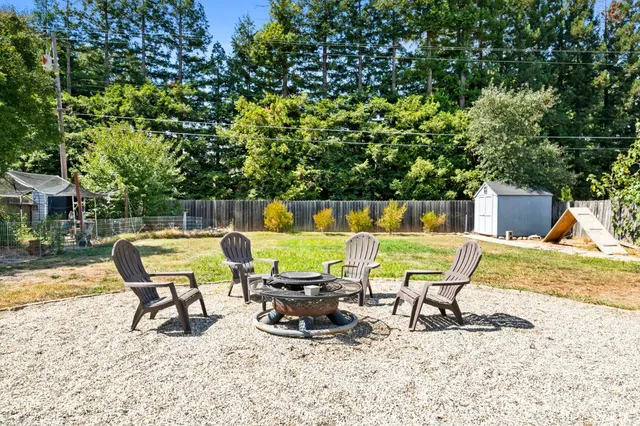 an aerial view of residential houses with outdoor space and trees all around
