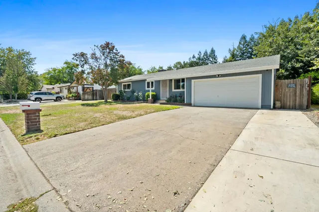 a front view of a house with a yard and trees