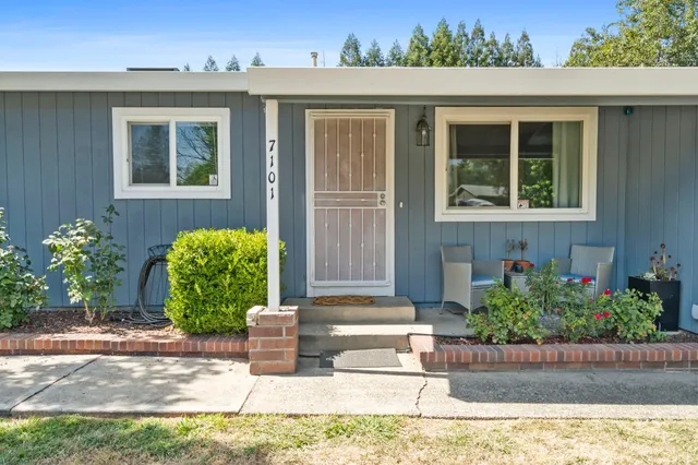 a view of house with yard and trees in the background