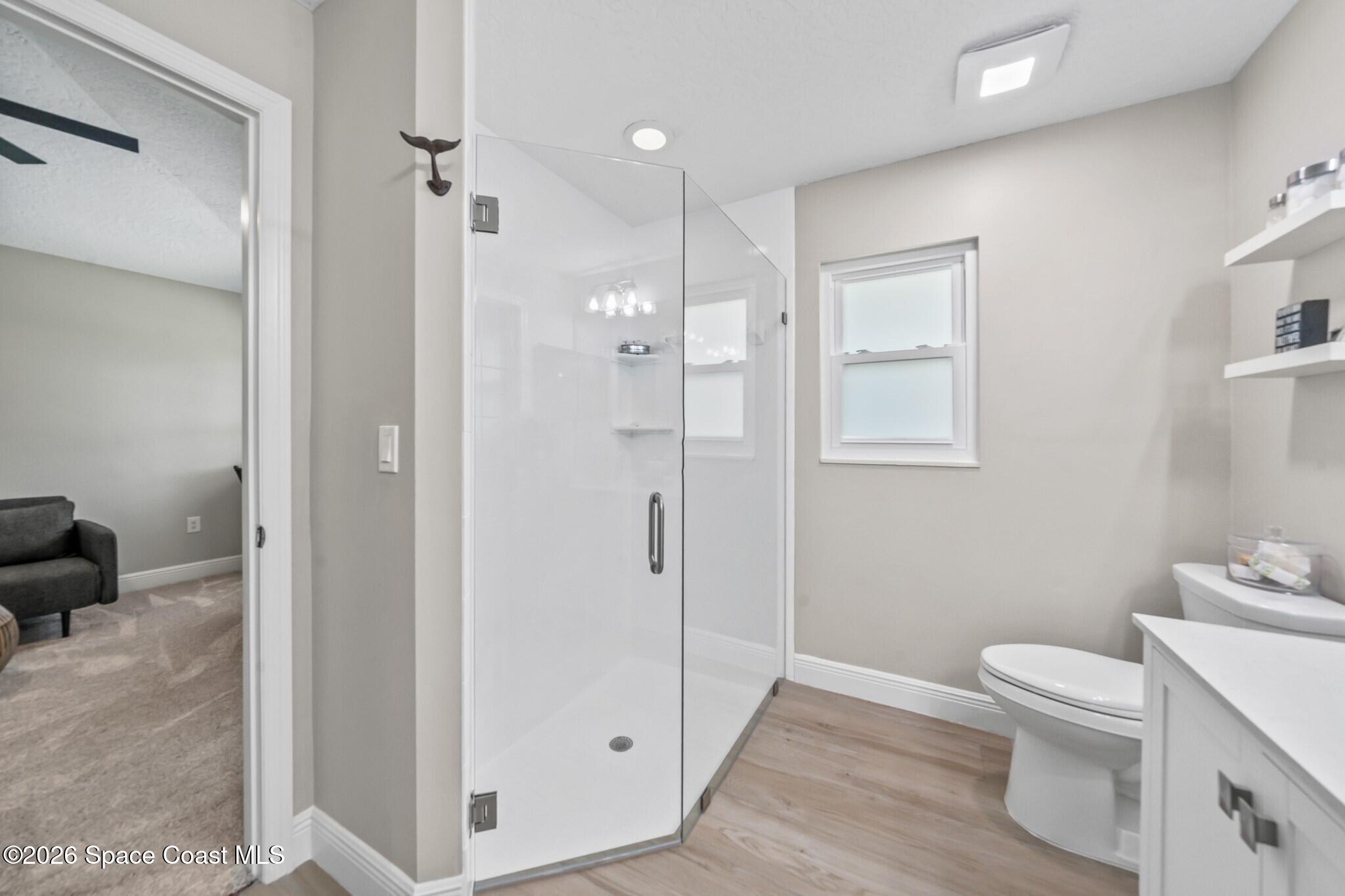 697 Spring Lake Drive Melbourne, FL 32940 - Photo 25 of 45 a bathroom with a shower a toilet and a sink