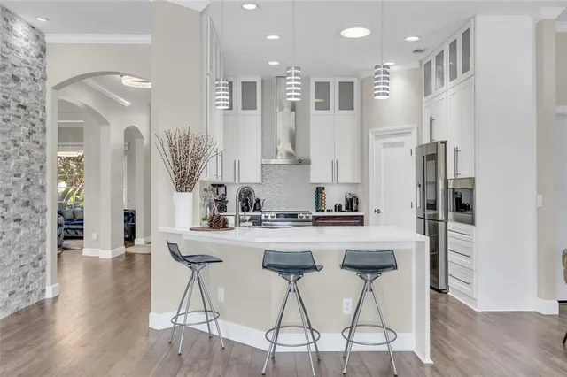 a kitchen with stainless steel appliances kitchen island granite countertop a refrigerator and a stove top oven