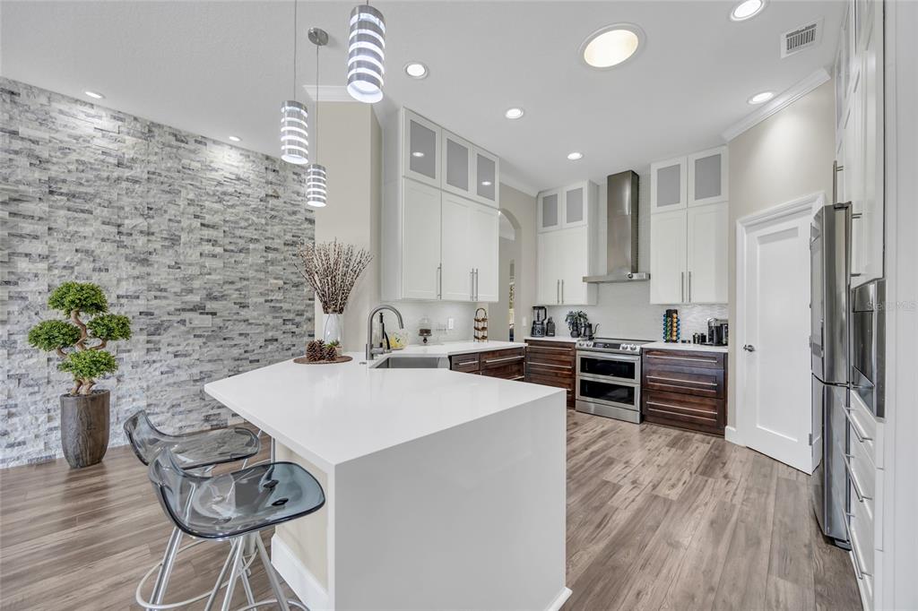 10600 Oakview Pointe Terrace Gotha, FL 34734 - Photo 9 of 44 a kitchen with stainless steel appliances kitchen island granite countertop a refrigerator a stove a sink and white cabinets with wooden floor