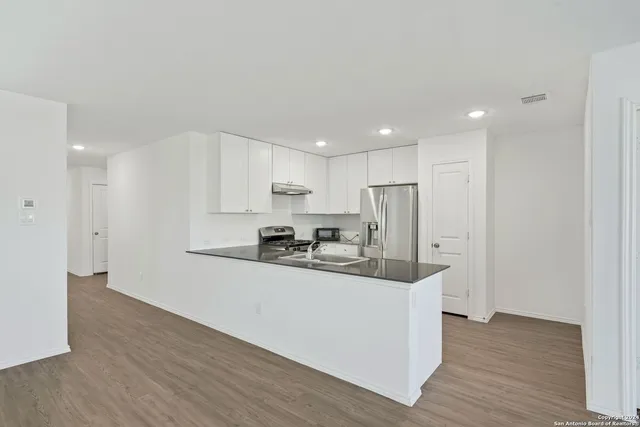 a kitchen with stainless steel appliances a sink and a refrigerator
