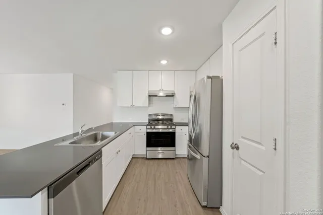 a kitchen with stainless steel appliances a stove a refrigerator and cabinets