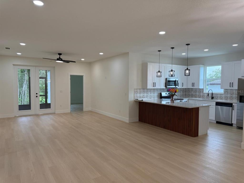126 Canby Circle Spring Hill, FL 34606 - Photo 14 of 45 a large kitchen with stainless steel appliances kitchen island a large counter top and a wooden floors