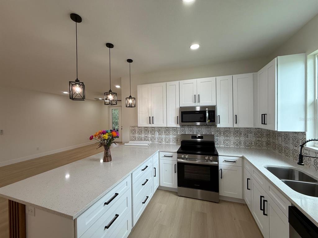 126 Canby Circle Spring Hill, FL 34606 - Photo 19 of 45 a kitchen with granite countertop a sink stove and cabinets