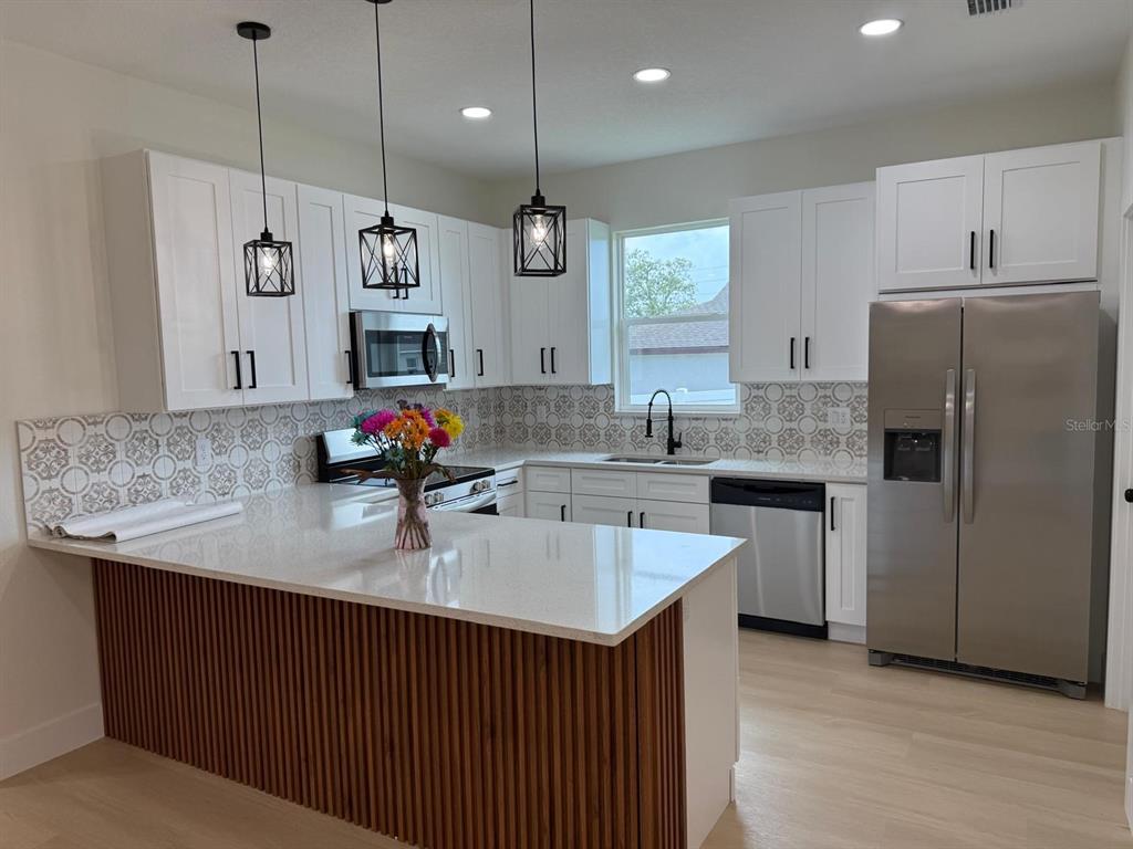 126 Canby Circle Spring Hill, FL 34606 - Photo 21 of 45 a kitchen with kitchen island a sink stainless steel appliances and refrigerator