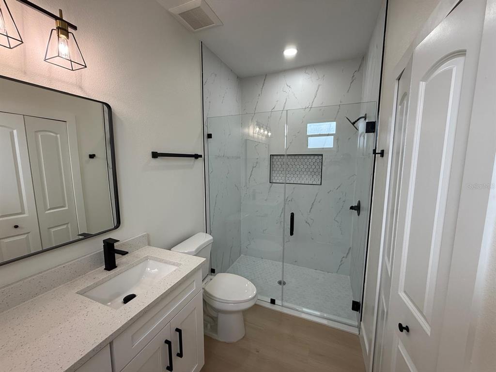 126 Canby Circle Spring Hill, FL 34606 - Photo 30 of 45 a bathroom with a double vanity sink toilet mirror and shower