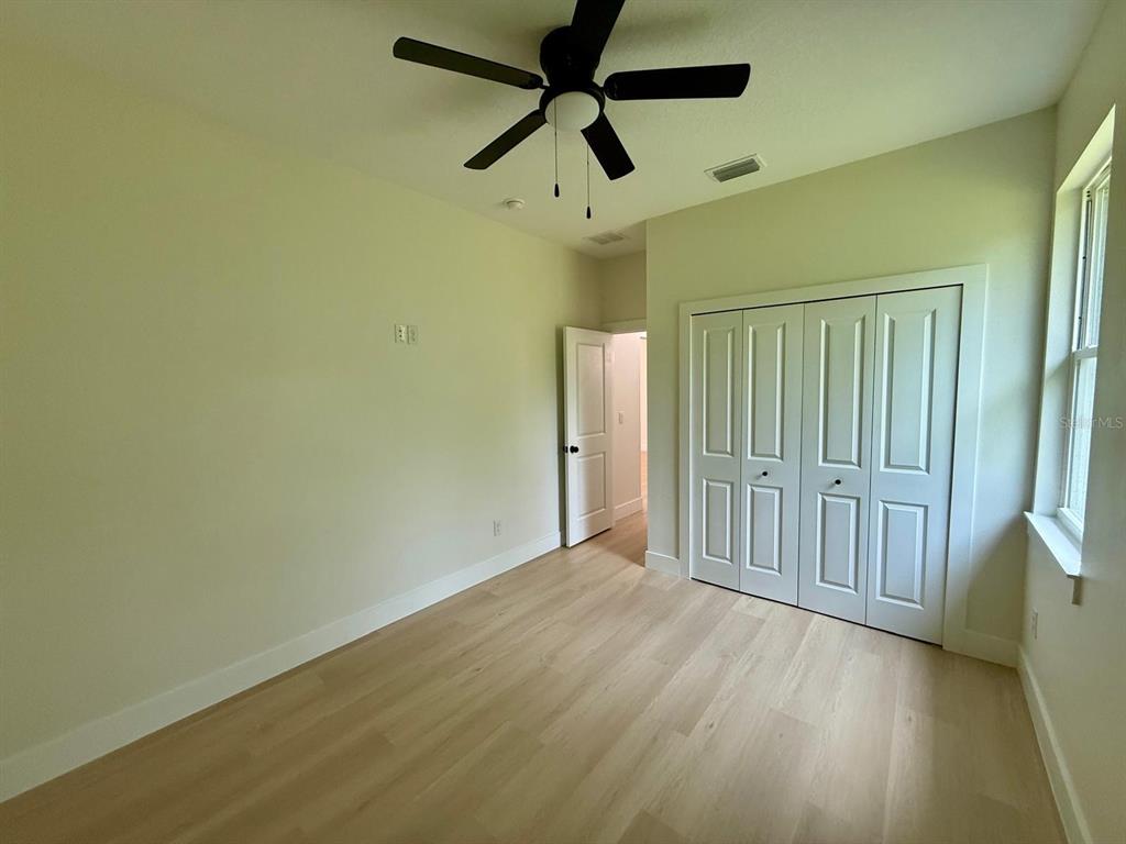 126 Canby Circle Spring Hill, FL 34606 - Photo 35 of 45 en empty room with wooden floor fan and windows