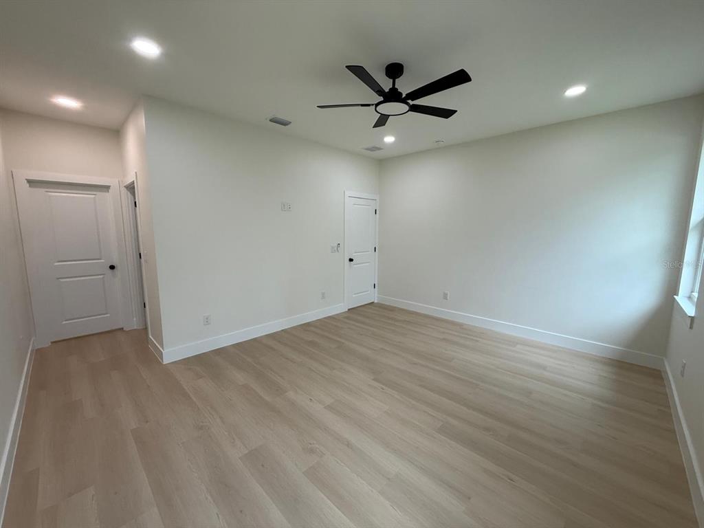 126 Canby Circle Spring Hill, FL 34606 - Photo 38 of 45 an empty room with wooden floor and a ceiling fan