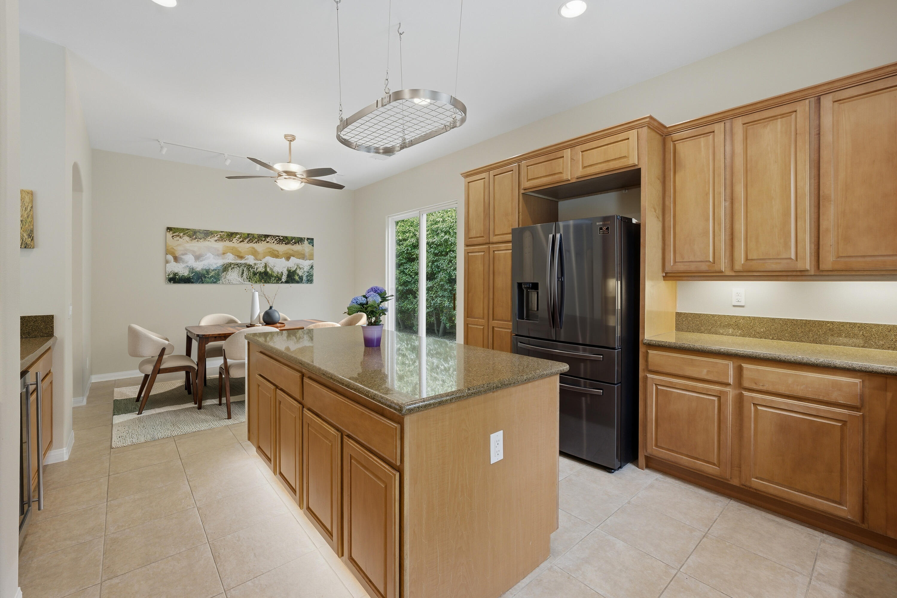 79120 Shadow Trail La Quinta, CA 92253 - Photo 25 of 60 a kitchen with stainless steel appliances granite countertop a sink and dishwasher a refrigerator with wooden cabinets
