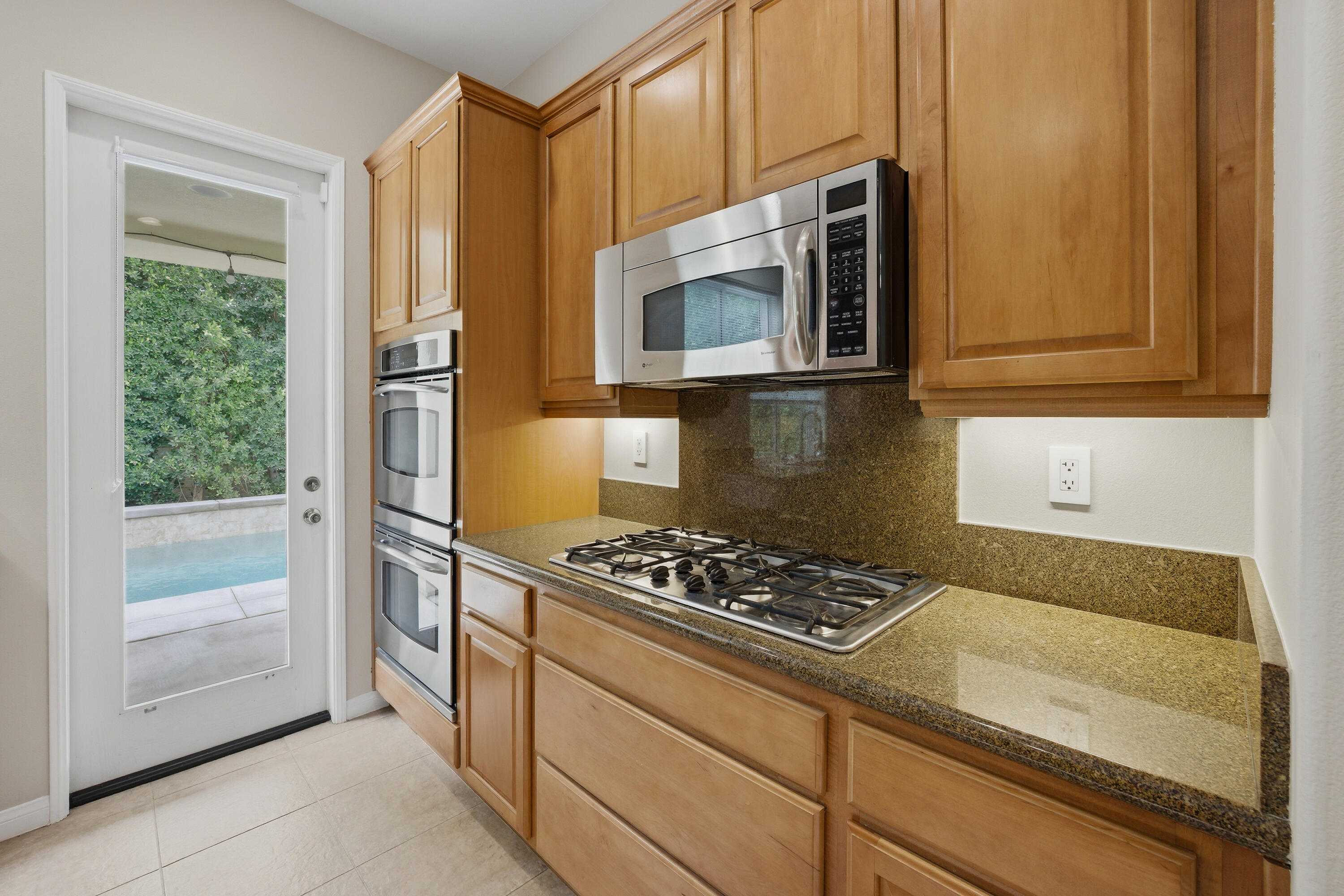 79120 Shadow Trail La Quinta, CA 92253 - Photo 30 of 60 a kitchen with stainless steel appliances granite countertop a stove and a microwave