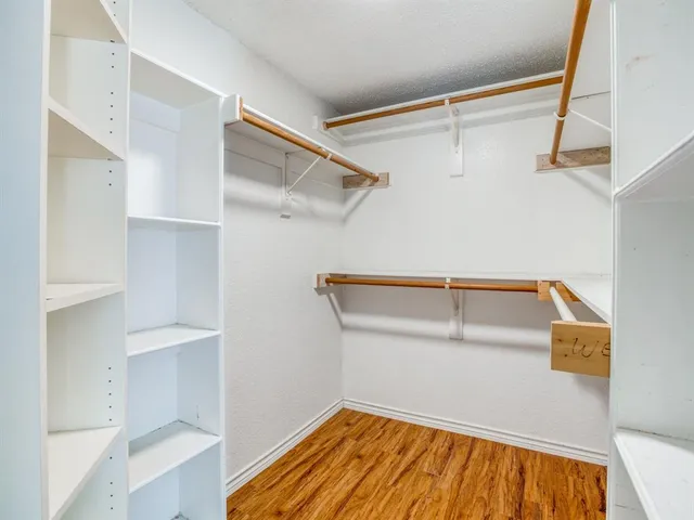 a view of walk in closet with empty racks
