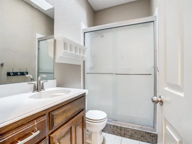 a bathroom with a sink a toilet and shower