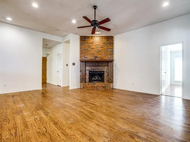 a view of empty room with wooden floor and fireplace