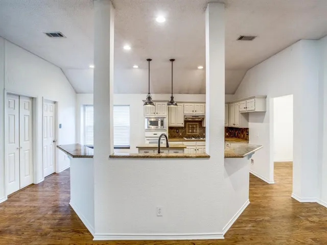 a view of a kitchen with kitchen island and stainless steel appliances