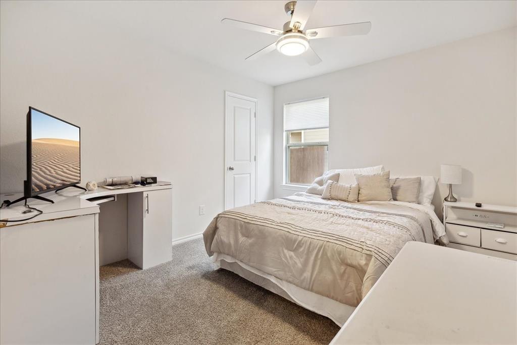 710 Primrose Lane Pilot Point, TX 76258 - Photo 8 of 13 a bedroom with a large bed and a flat tv screen on a dresser