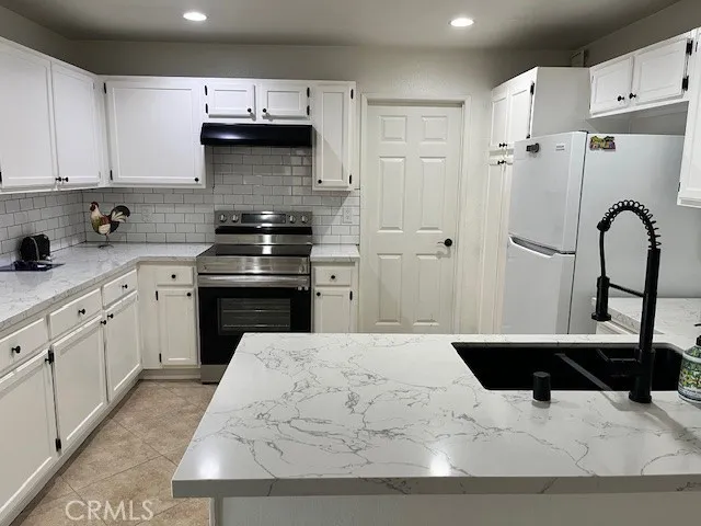 a kitchen with stainless steel appliances kitchen island a sink stove and refrigerator