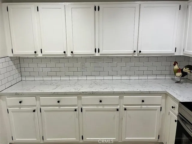 a view of a kitchen with white cabinets
