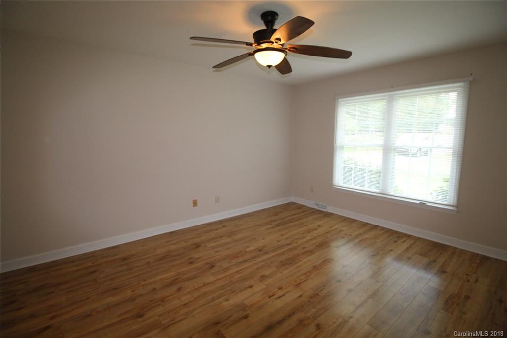 1715 Carmel Church Road, Unit 2 Monroe, NC 28112 - Photo 11 of 19 an empty room with wooden floor fan and windows