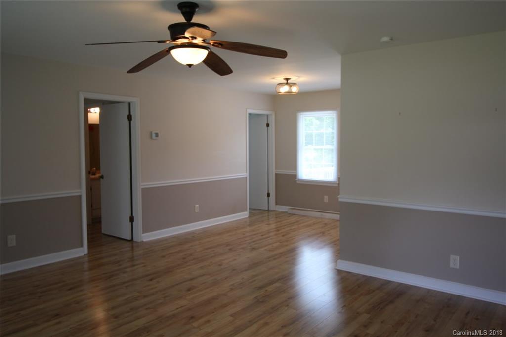 1715 Carmel Church Road, Unit 2 Monroe, NC 28112 - Photo 3 of 19 a view of an empty room with wooden floor and a ceiling fan