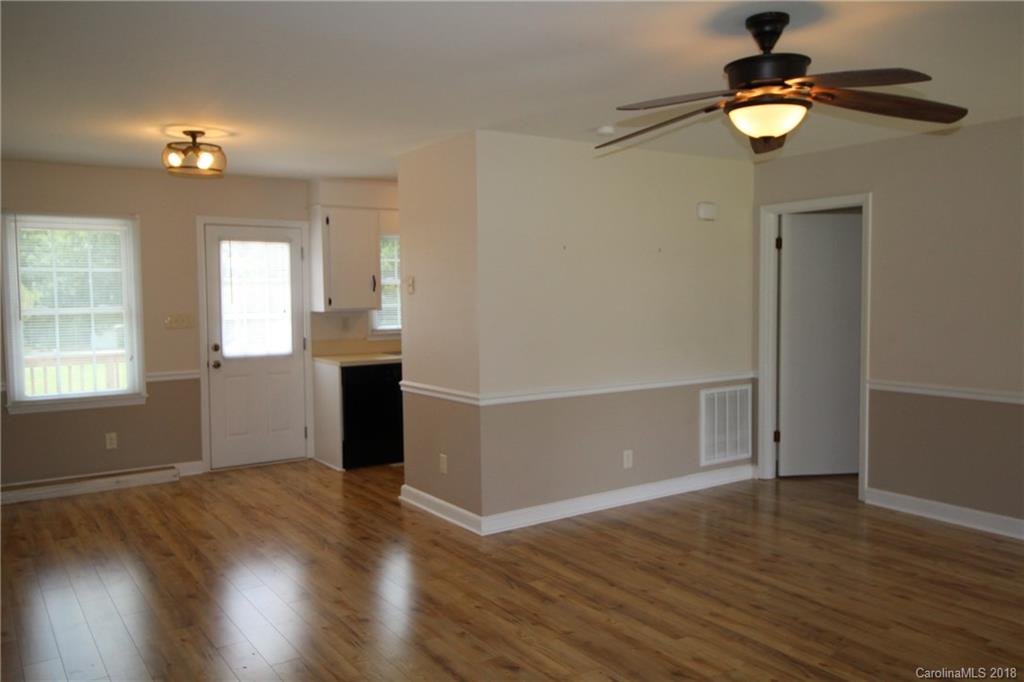 1715 Carmel Church Road, Unit 2 Monroe, NC 28112 - Photo 8 of 19 an empty room with wooden floor chandelier and windows