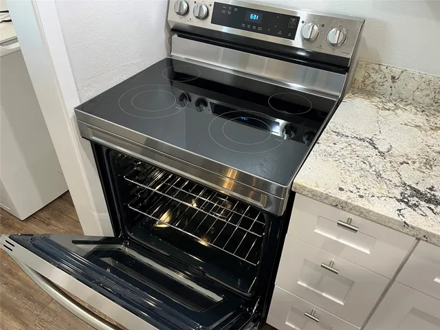 a kitchen with a stove and white cabinets