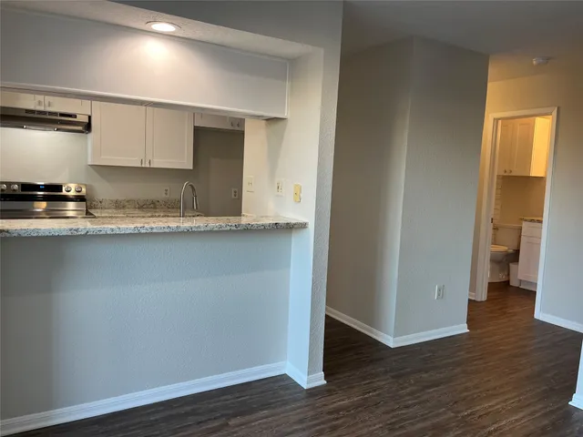 an empty room with wooden floor and chandelier fan