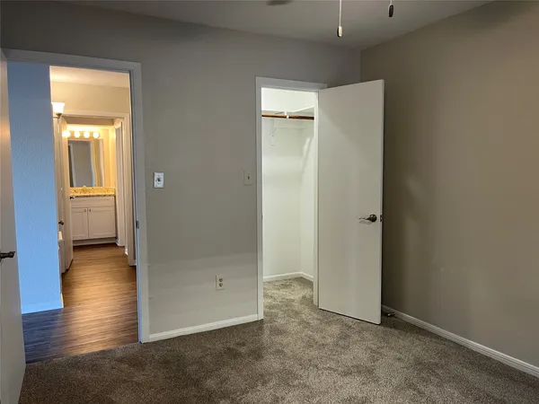 an empty room with a ceiling fan and window