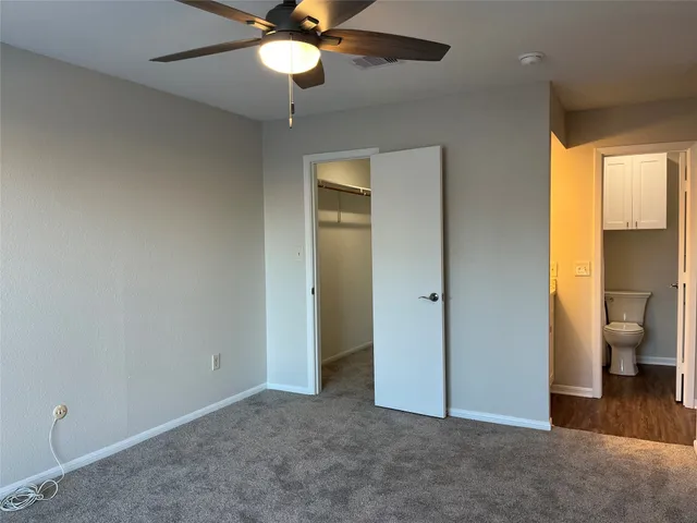 an empty room with a ceiling fan and window
