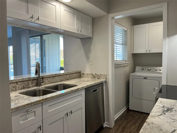 a kitchen with a sink cabinets and a wooden floor