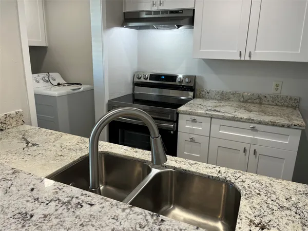a kitchen with a stove and white cabinets
