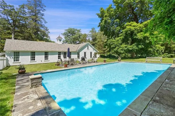 a view of a house with swimming pool and sitting area