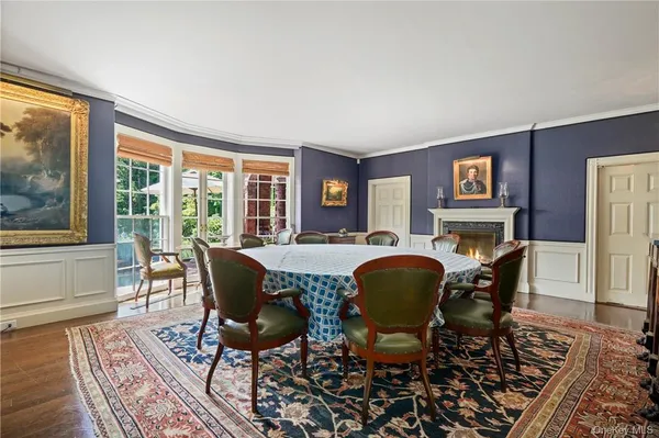 a dining room with furniture a fireplace and wooden floor