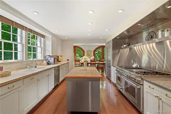a large kitchen with stainless steel appliances lots of counter space and wooden floor